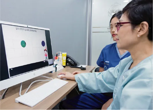 환자가 모니터 앞에 앉아 전산화 인지재활 프로그램을 하고 있다