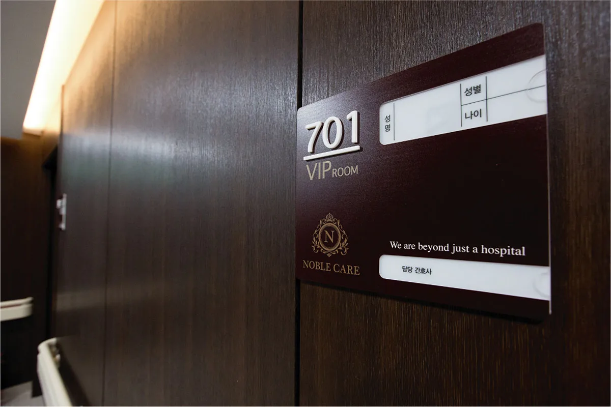 701호 VIP ROOM 명패. 노블케어 엠블럼과 We are beyond just a hospital 문구가 새겨져 있다
